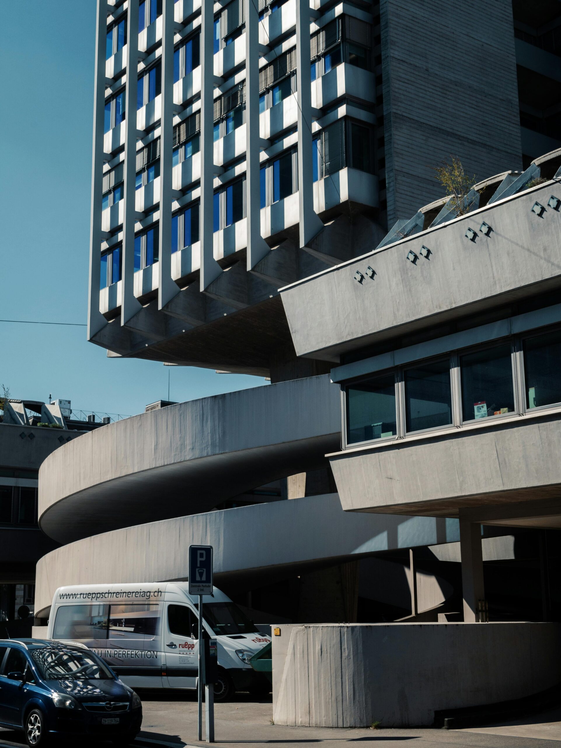 A striking photograph of a modern brutalist office building with unique architectural features.